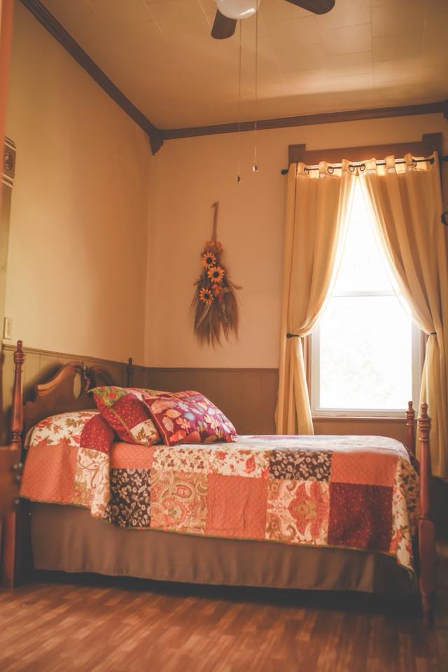 Our Fall Room has a Double Bed with a pieced block pattern Quilt in vibrant Fall colors.  The bed is a four-poster dark wood bed.  A large bathroom is located within the room with a bathtub.