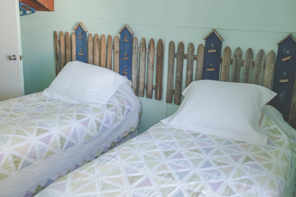 Our Spring Room has 2 twin beds with picket fence headboards.  Decorated in a fresh spring green with a sky blue ceiling, this room is calming and relaxing. 